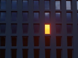 one light on in dark apartment building