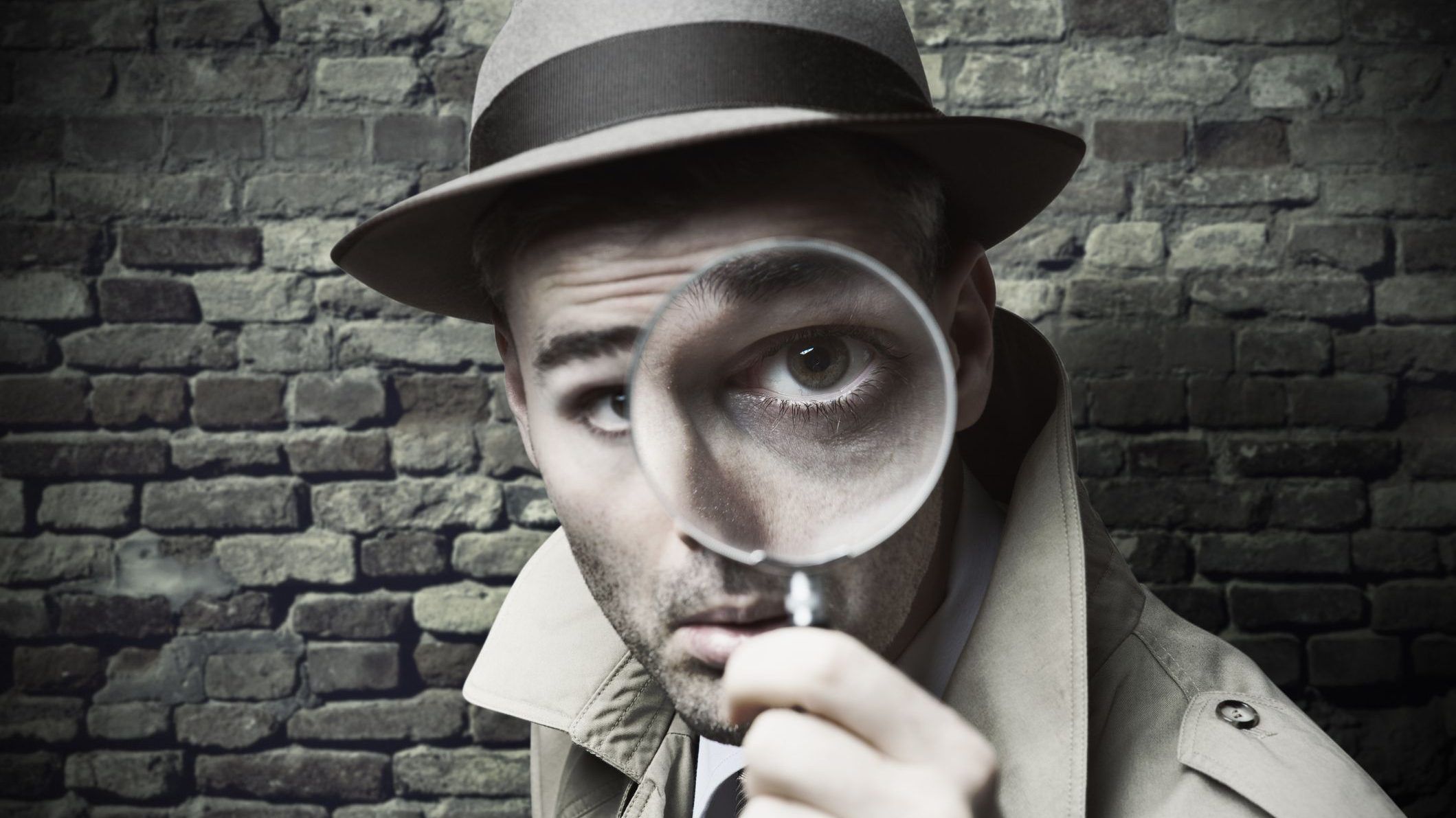 Vintage detective looking through a magnifier