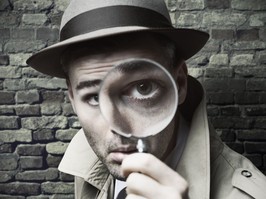 Vintage detective looking through a magnifier