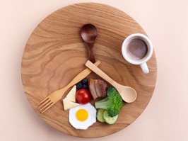 wooden plate with just one meal a day (OMAD) stationed like a clock