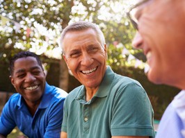 Mature Male Friends Socializing In Backyard Together