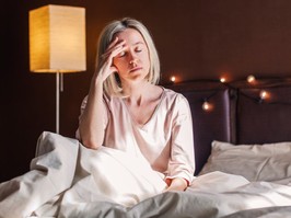 Middle age woman sitting in a bed having trouble sleeping