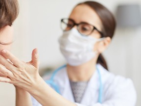 Doctor examining a patient's thyroid glands.