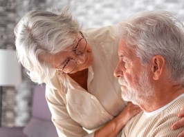 Old worried senior woman comforting her depressed, mental ill husband, unhappy elderly man at home need medical help.