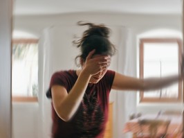 Blurred photo of woman suffering from vertigo or dizziness or other health problem of brain or inner ear.