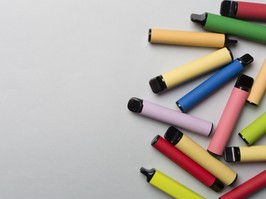 Disposable electronic cigarettes on color background, top view