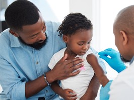 Healthcare, medical and doctor with child patient cleaning shoulder with hygiene material with help and support of father. Kid at appointment with health professional clean arm for shot or injection