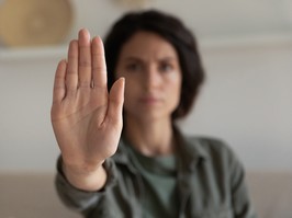 Young woman showing palm, making hand stop denial gesture