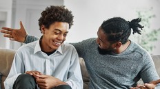 Portrait of a happy teenage boy son talking to his father at home. Sharing secrets and having fun, support and parenthood concept