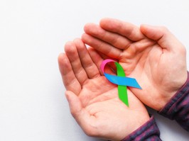 man holding a symbol of World Rare Disease Day