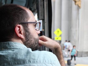 Samuel Dunsiger - man stares out a window at pedestrians.