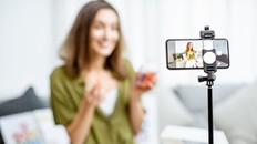 Young woman recording her vlog about healthy eating and nutritional supplements, close-up on a phone screen. Preventive medicine and influencer marketing concept