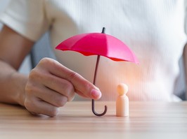 hand holding red umbrella and cover wood man. People protect, Life Insurance, health and leadership Concepts