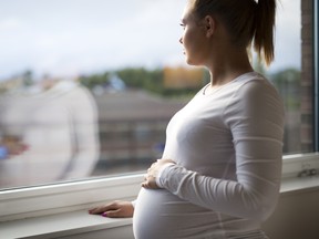 pregnant woman looking out window