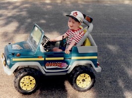 Young boy, Jeremy Bray, driving a toy truck.