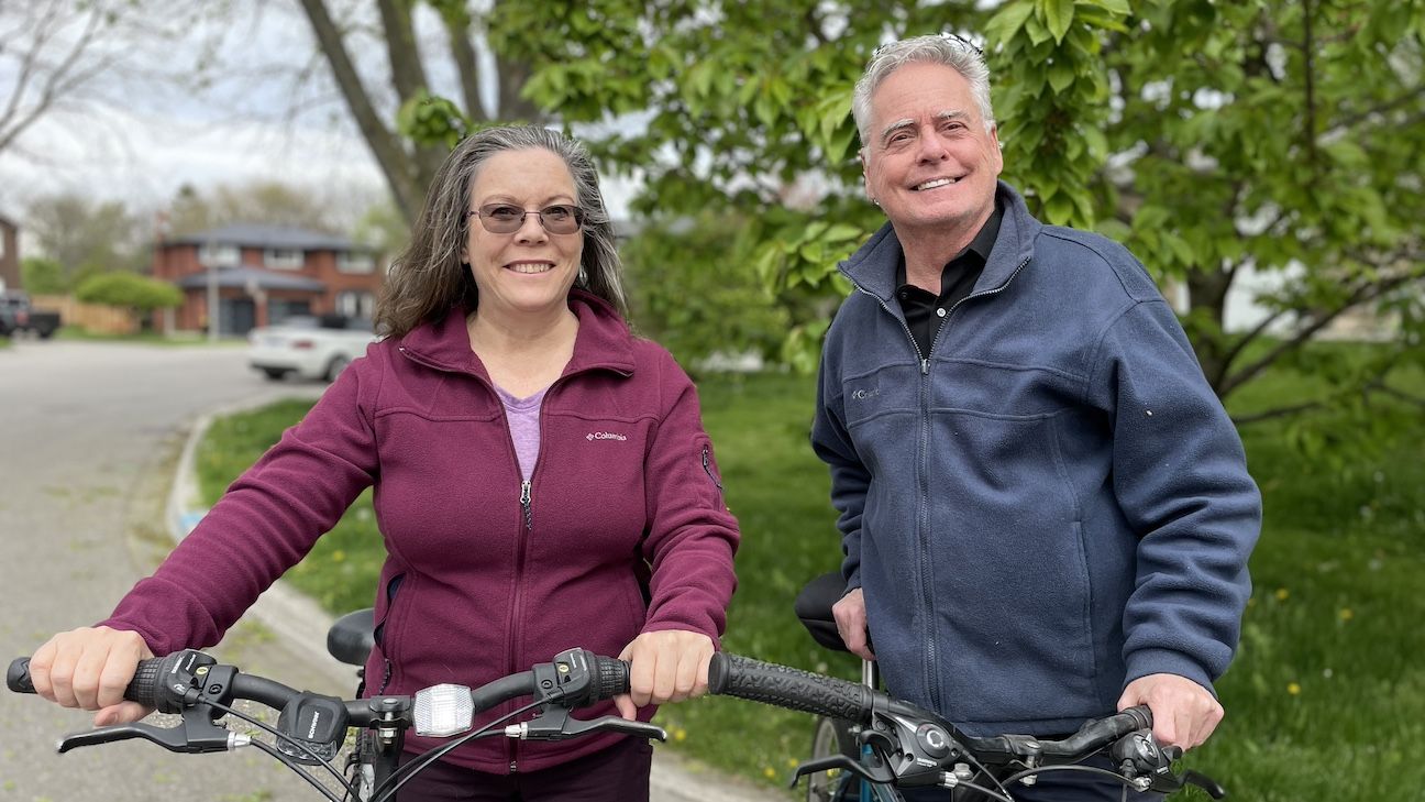 France Carbonneau and Rick Livingstone posing for a photo while bike riding
