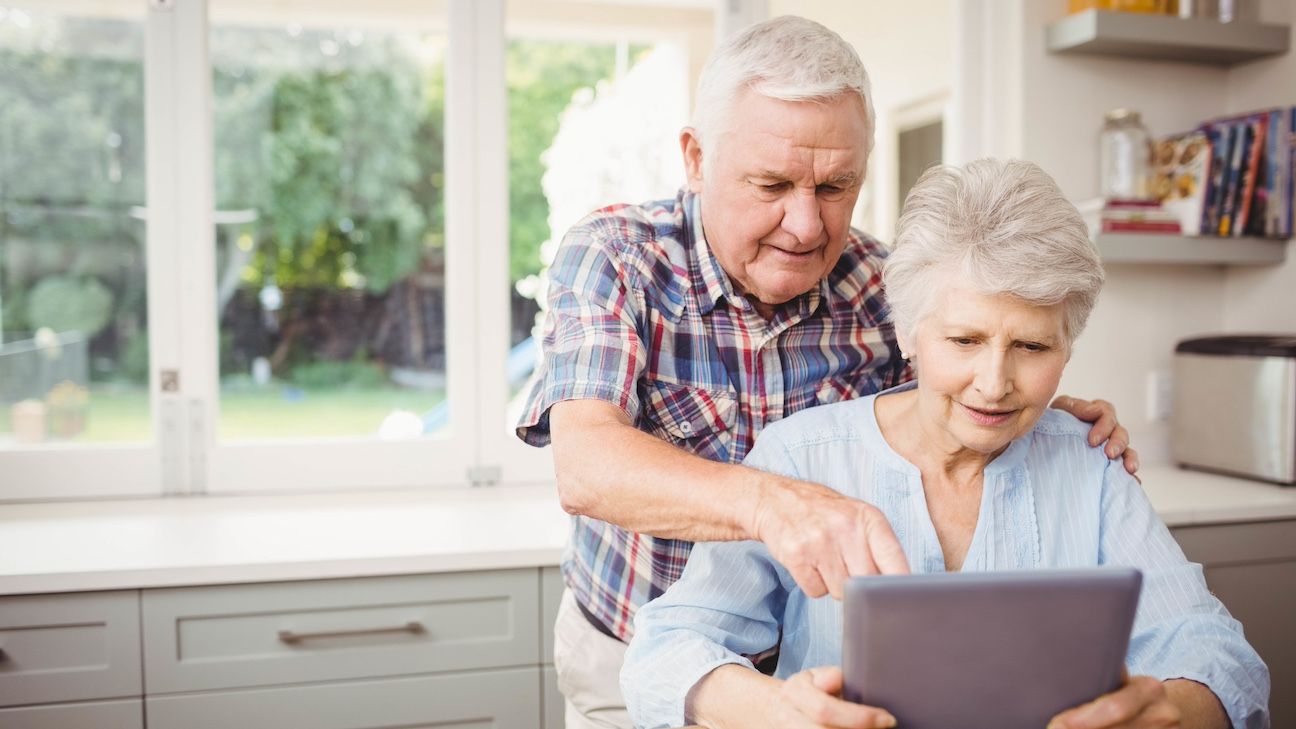 Senior couple using digital tablet at home
