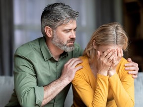 Caring Middle Aged Man Comforting His Depressed Crying Wife At Home, Upset Female Suffering Mental Breakdown, Sobbing And Covering Face With Hands While Loving Husband Soothing Her, Closeup Shot