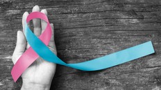 Pink blue ribbon awareness (isolated with clipping path) bow color for newborn birth defect, Sudden Infant Death Syndrome (SIDS), pregnancy Loss on helping hand