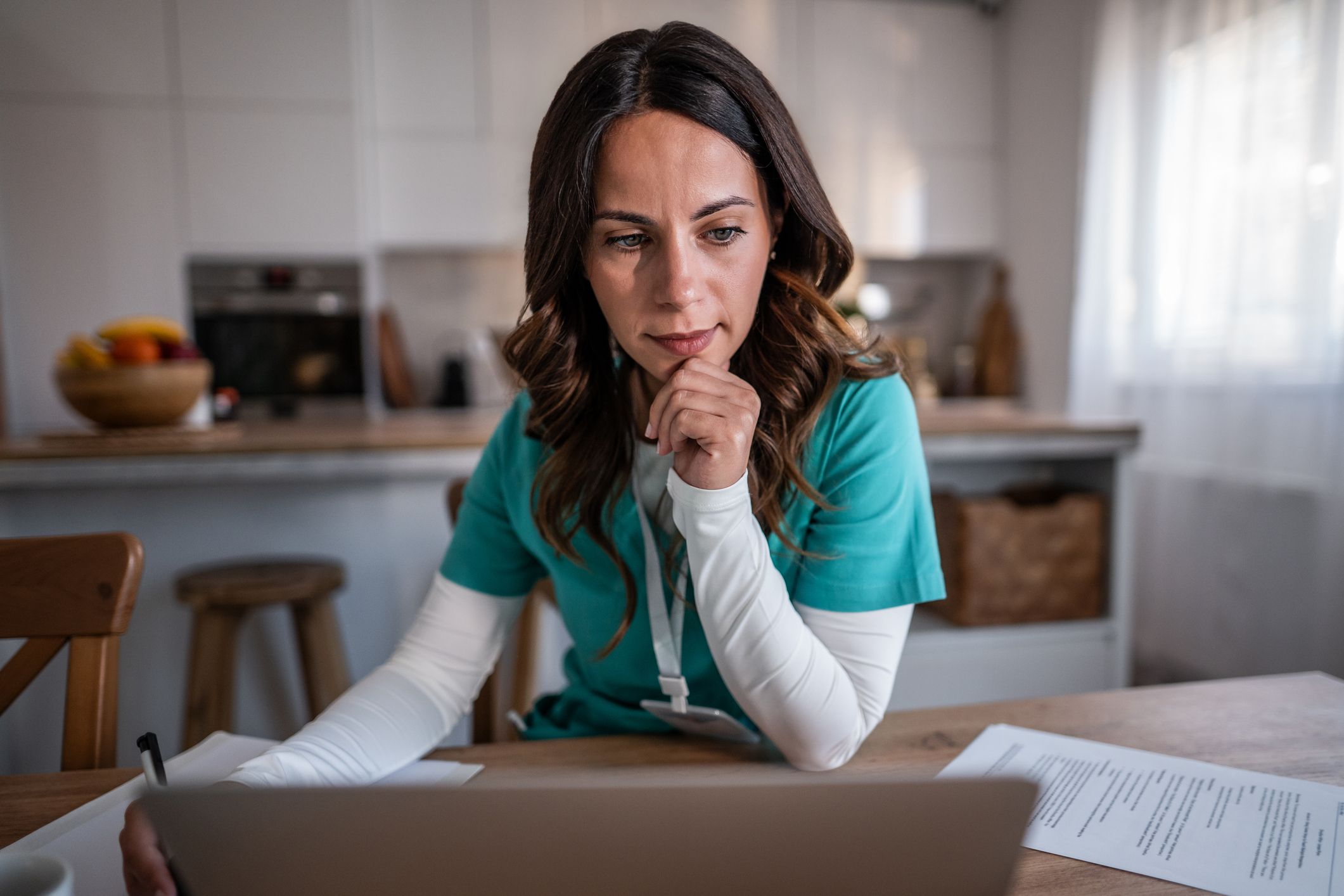 female doctor working remotely on laptop from home