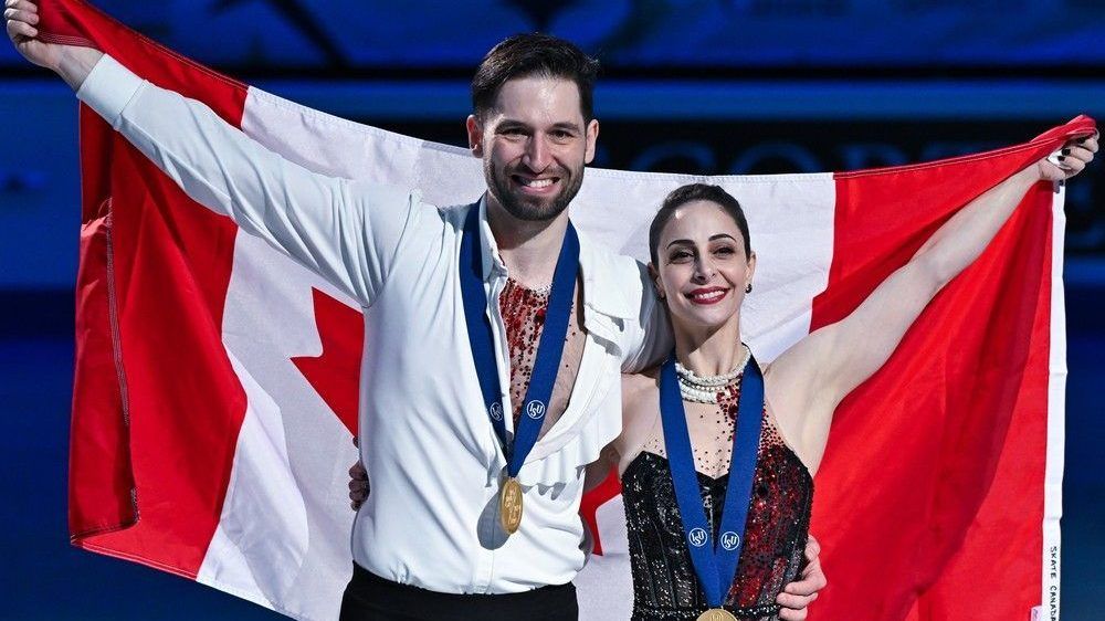 Deanna Stellato-Dudek and Maxime Deschamps pose with a Canadian flag and their gold medals after finishing first in the pairs free program during the ISU World Figure Skating Championships at the Bell Centre on March 21, 2024, in Montreal.