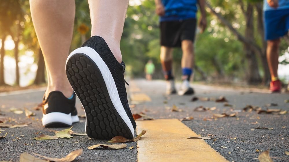 Cutoff picture of people walking. Feet only in running shoes.