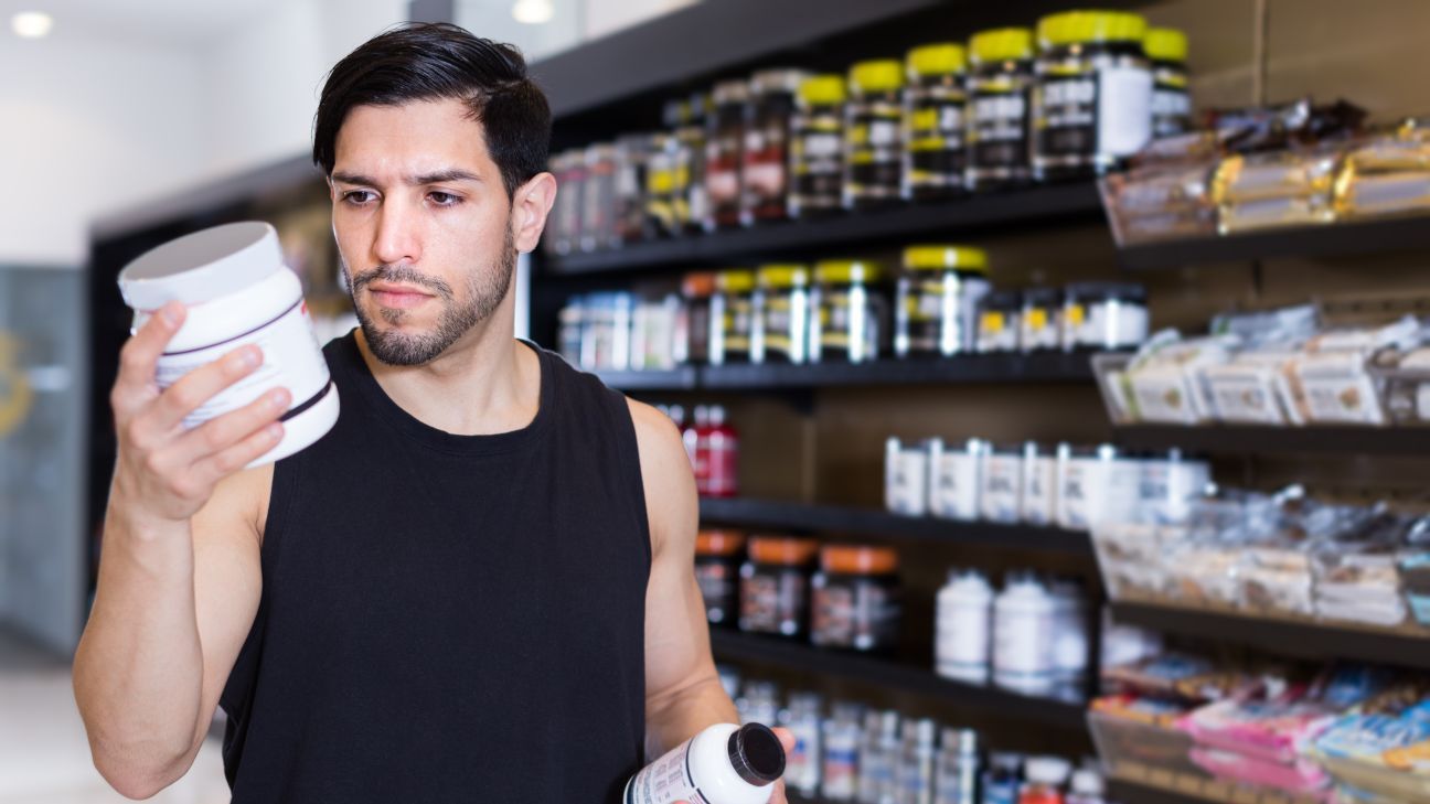 Man looking at information on a supplements bottle.