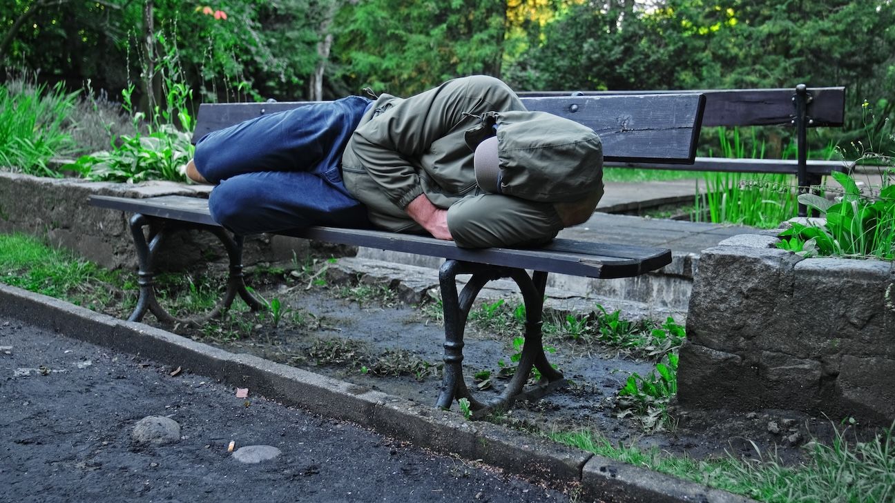 Homeless Man Sleeping on Park Bench