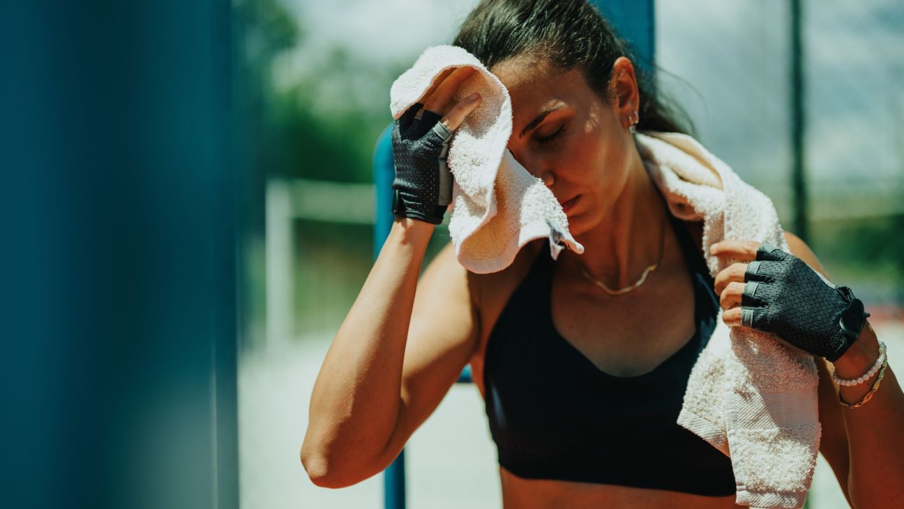 Woman towels her brow after outdoor summer workout.