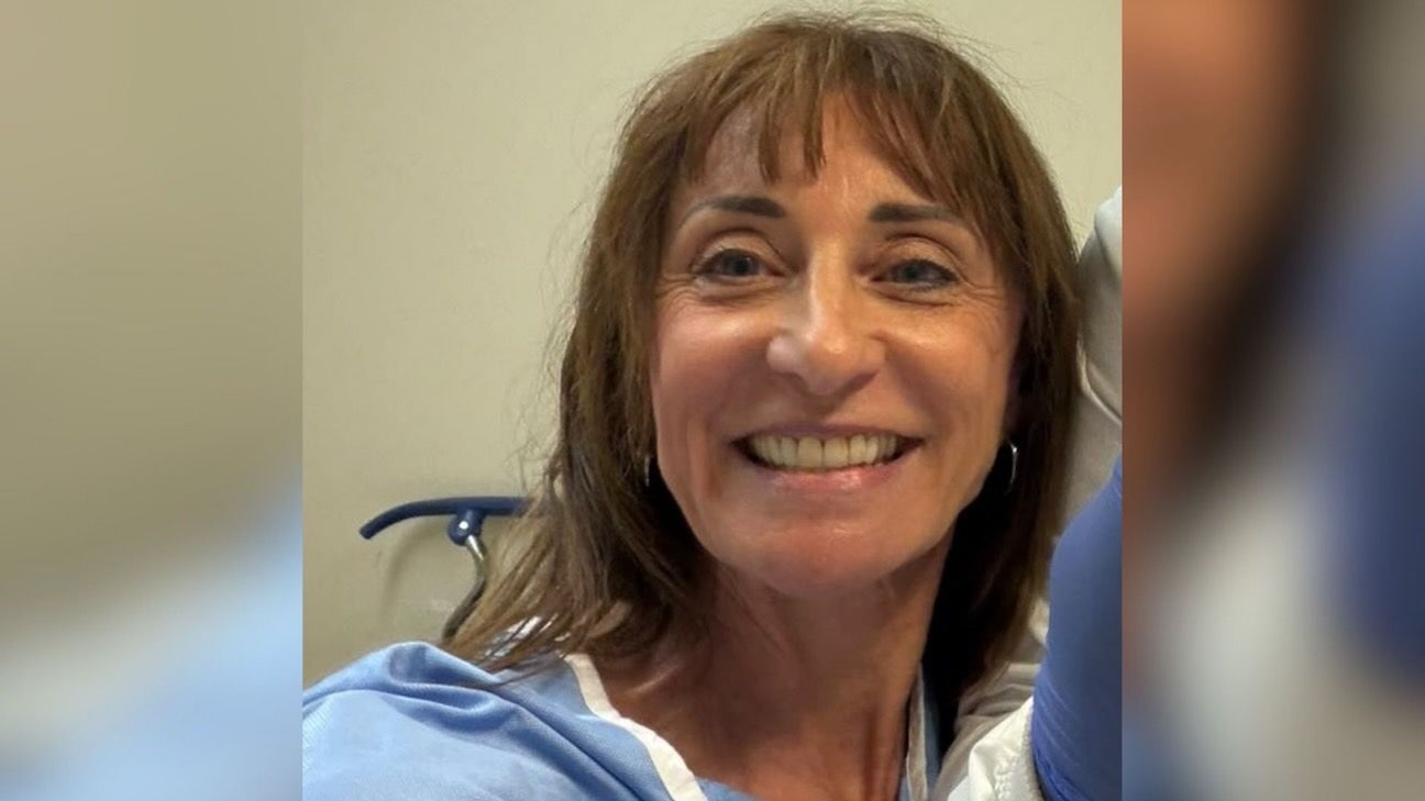 A close up photo of a women in a hospital gown smiling