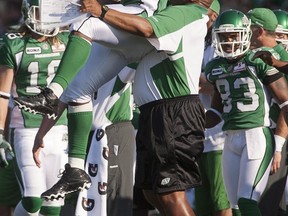 Mike Walker (right) and Brent Hawkins celebrate a fumble recovery by Hawkins on Sunday (THE CANADIAN PRESS/Liam Richards)