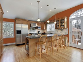 Create a welcoming feel in a kitchen with wood cabinetry by painting the walls a cozy shade of warm orange, such as Persimmon Berry (60YR 26/605 DL10) by CIL paint, featured on the walls of this room. CIL photo