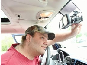 Daryl Siba adjusts the dash cam on his car. Siba discovered on May 30 that someone had dumped poutine on his car outside his Regina apartment. His dash cam recorded a woman he doesn’t know dumping the poutine on his car.