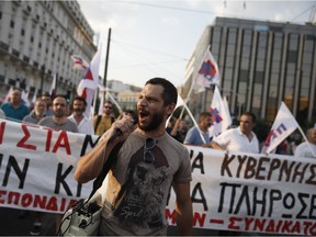 A members of the Communist-affiliated PAME labor union shouts slogans during an anti-austerity rally in Athens, Friday, June 10, 2015. Greek Prime Minister Alexis Tsipras sought his left-wing party's backing on Friday for a new budget austerity package that is harsher than what he urged Greeks to reject in a vote just last week, but would provide the country will longer-term financial support.