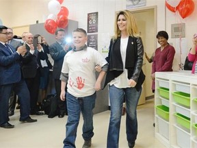 Brayden Nelson, left, accompanies Shania Twain, right, into a room for the launch of Shania Kids Can Clubhouse at Judge Bryant School in Regina, Sask. on Saturday Oct. 17, 2015. Twain’s foundation aims to supports children who suffer from poverty, disregard, and abuse.