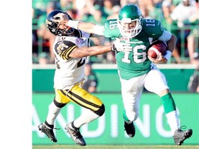 Brett Smith, right, shown trying to elude the Hamilton Tiger-Cats’ Emanuel Davis on Sunday, is to start at quarterback Friday for the Saskatchewan Roughriders when they face the host Edmonton Eskimos.