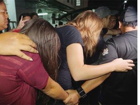 Canadian Danielle Petersen, 22, center right, and left, Eleanor Hawkins, 24, left, of Britain are escorted by police as they leave court in Kota Kinabalu, in eastern Sabah state on Borneo island, Malaysia, Friday, June 12, 2015. Both women were among the 10 people who stripped naked and took photos on Mount Kinabalu on May 30. A local official has said the foreigners’ behavior caused an earthquake near the mountain last Friday that killed 18 climbers.