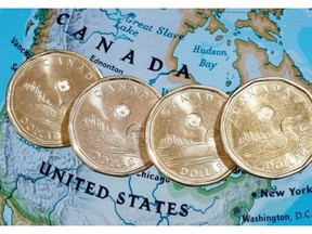 Canadian dollar coins, or Loonies, are displayed on a map of North America January 9, 2014 in Montreal. THE CANADIAN PRESS/Paul Chiasson ORG XMIT: CPT123