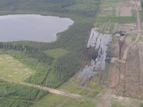 Crews work to clean the spill of bitumen, water and sand by  Nexen's Long Lake facility near Fort McMurray Alta. on Friday July 17, 2015.