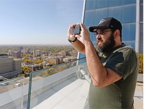 Derek Jaworski snaps a pic of the city from the roof of Hill Tower III during a Doors Open event in Regina, Sask. on Saturday Sep. 26, 2015. An initiative of the Regina Downtown Business Improvement District, the activities give the public a chance to experience the city's downtown buildings and heritage. (Michael Bell/Regina Leader-Post)