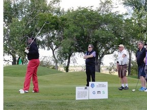 A gallery looks on as George Reed Tees off during the Bob Hughes Classic golf tournament for Special Olympics at the Wascana Golf and country club Monday June 22, 2015.