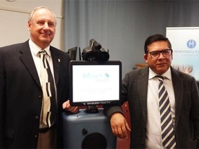 George Partyka, CEO of Partner Technologies Incorporated, left, and Dr. Ivar Mendez, Unified Head, Department of Surgery, College of Medicine, University of Saskatchewan flank the robot named PeTIr.
