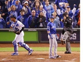 Kansas City Royals catcher Salvador Perez, left, celebrates after Toronto Blue Jays' Troy Tulowitzki strikes out during the sixth inning in Game 1 of baseball's American League Championship Series on Friday, Oct. 16, 2015, in Kansas City, Mo.