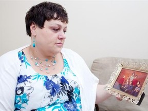 Kerri Wendland sits in her home holding a family, photo circa 1979 on Monday, July 13, 2015 in Lloydminster, Alta.