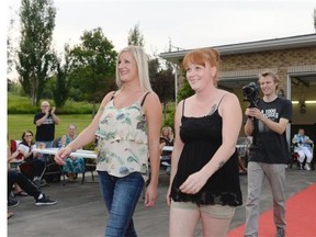 Kristin Boon, left, and Jessica Molnar, center, walk down a red carpet followed by videographer Nick Lamb, right, at the home of Bruce Robinson (not pictured) in Lumsden, Sask. on Saturday Aug. 29, 2015. Boon and Molnar gave-up smoking approximately one year ago.