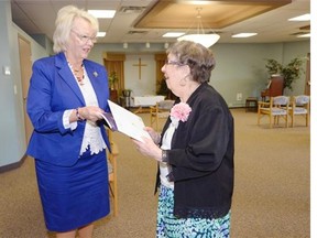 Lieutenant Governor Vaughn Solomon Schofield, left, presents Charlotte Ayers with a birthday gift at Broadway Terrace in Regina on Wednesday.  The event was held to help celebrate the Queen’s historic reign and Ayers will be celebrating her 100th birthday this month.