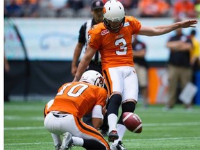 B.C. Lions’ Richie Leone, right, kicks a 48-yard single-point convert, setting a CFL record, as quarterback Jonathon Jennings holds during the first half of a CFL football game against the Ottawa Redblacks in Vancouver, B.C., on Sunday, September 13, 2015.