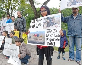 Maryam Rizvi, right, holds a sign during a rally on the Syrian refugee situation held at Victoria Park in Regina on Sept. 5, 2015. (Michael Bell/Regina Leader-Post)