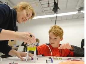 Megan Smith, left, an assistant professor at the faculty of fine arts lends a hand to six-year-old Sacha Scoular, right, during The Big Draw Event in the Creative Technology Maker Space at the University of Regina, Sask. on Saturday Oct. 3, 2015. The maker space is a lab within the Faculty of Fine Arts that provides students and the community access to tools in the areas of computer science, engineering, and art. (Michael Bell/Regina Leader-Post)