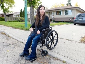 Michelle Deschamps demonstrates how her wheelchair gets stuck leaving her driveway in Regina on Sept. 23, 2015. She is hoping the city will repair the road, allowing her access to the street. (TROY FLEECE/Regina Leader-Post)